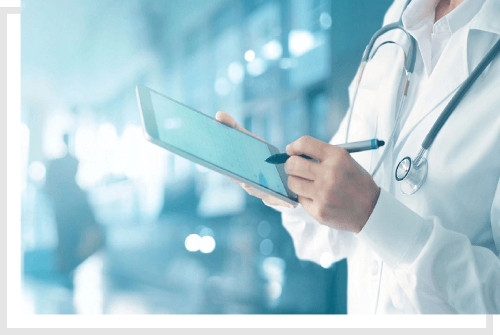 A doctor holding a tablet and writing on it.