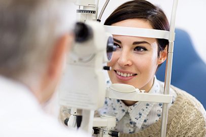 A woman is looking into the mirror of an eye exam.