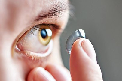 A person holding an eye glass in their hand.